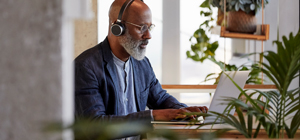 Man using a laptop wearing headphones