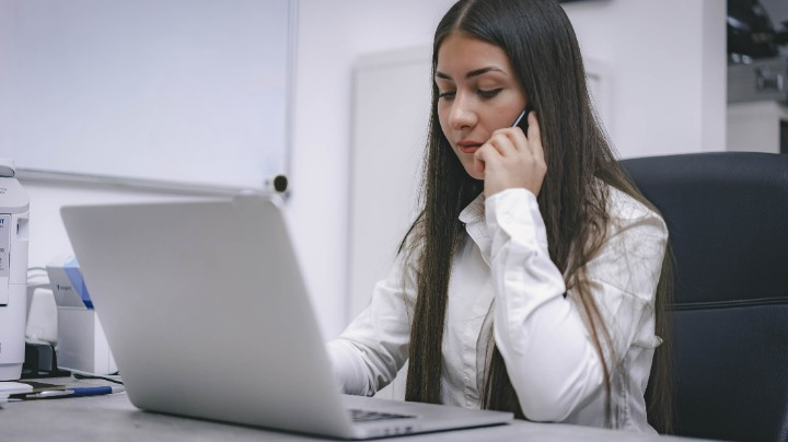 Person on the phone using a laptop